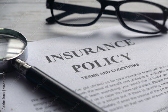 A pen and glasses on top of an insurance policy.