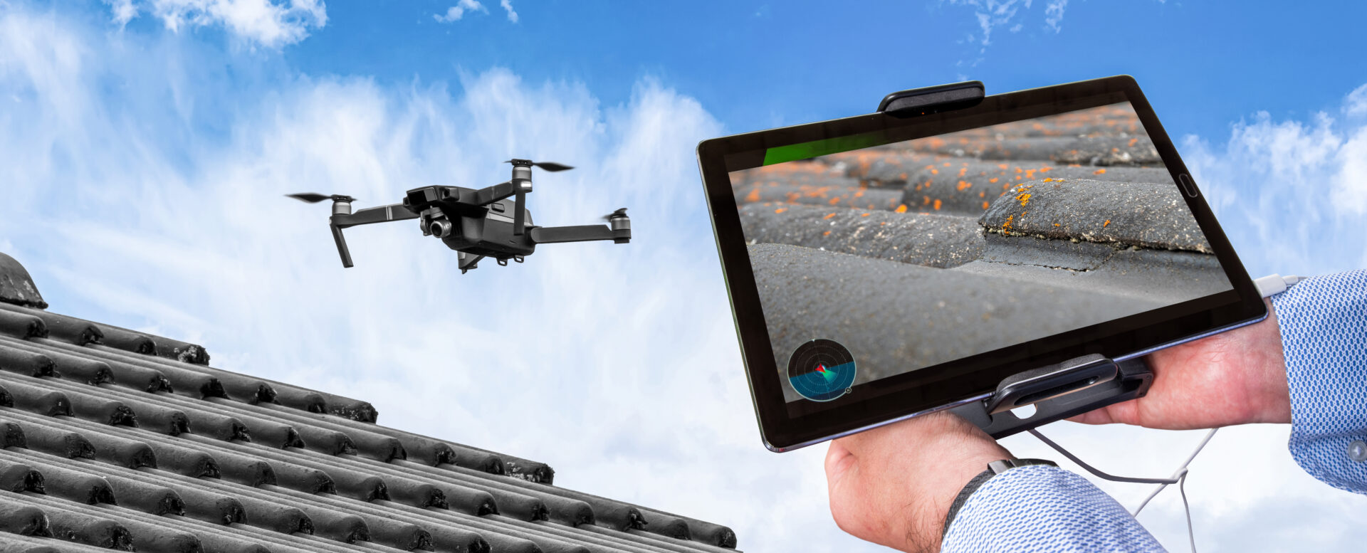 A person holding up a tablet with an image of a drone flying over.